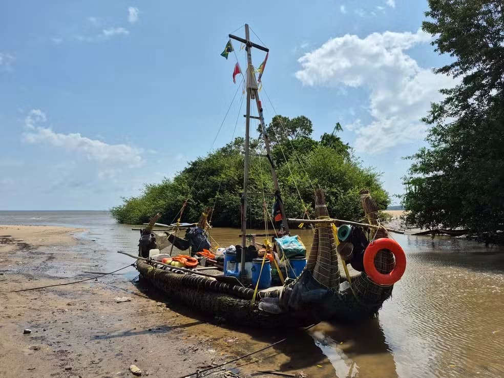 La balsa, mât pavoisé, échouée sur une plage bordée de mangrove près de l'embouchure de l'Amazone